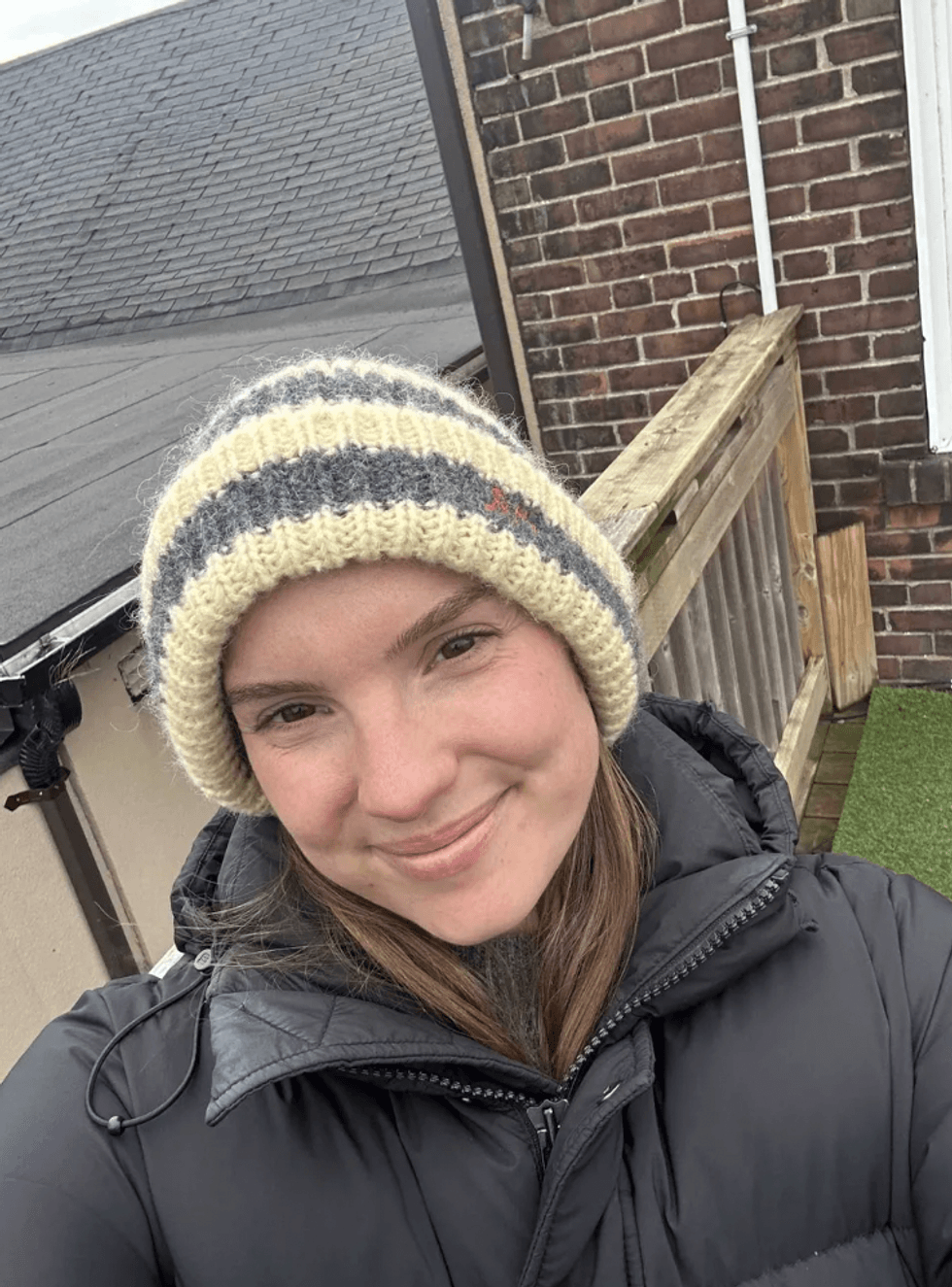 A woman wearing a winter hat and black puffer coat.