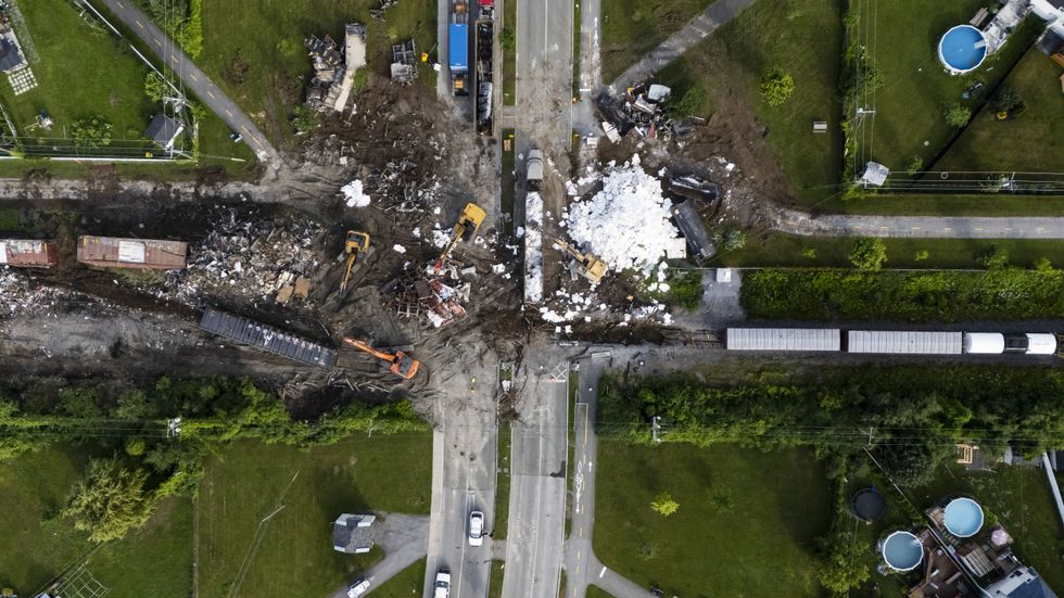 Aerial view of cleanup of a derailed cargo train.