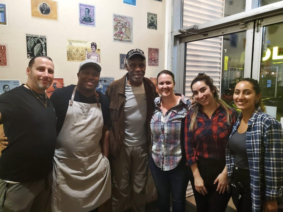 American actor Danny Glover with standing among employees in Haitian restaurant Kwizinn Verdun.