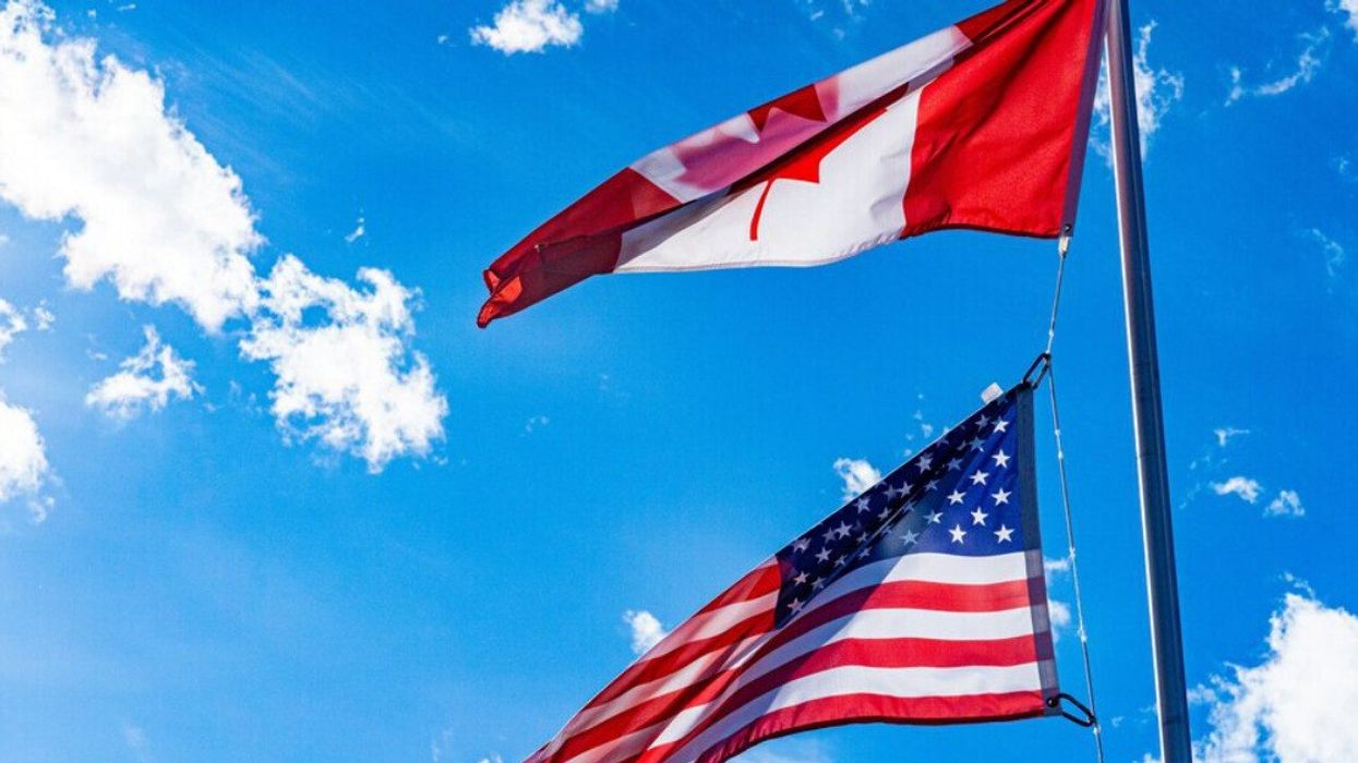 American and Canadian flags flying in the wind.