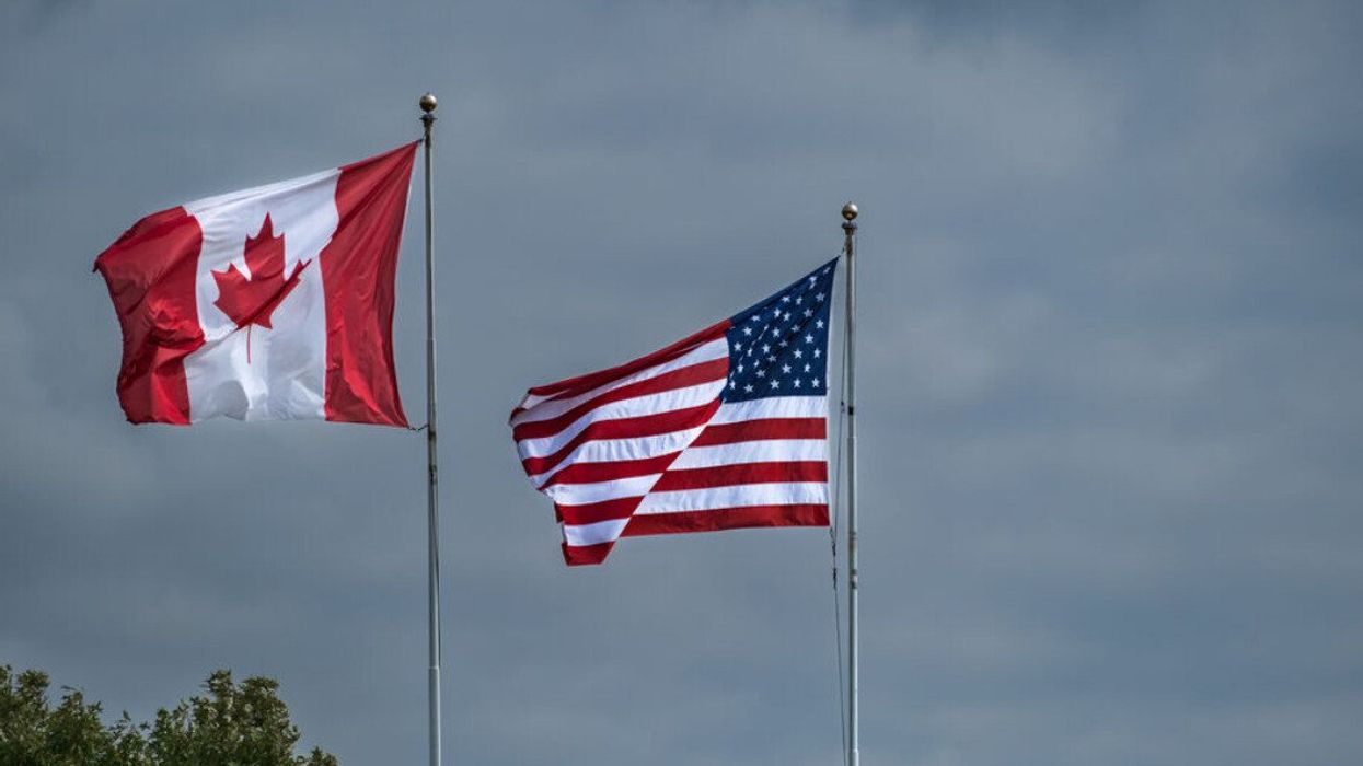 American and Canadian flags flying side by side at the border between USA-Canada.