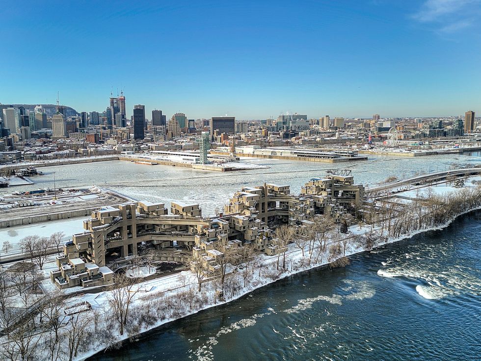 An aerial view of Habitat 67 with the Montreal Old Port and downtown skyline in the background.