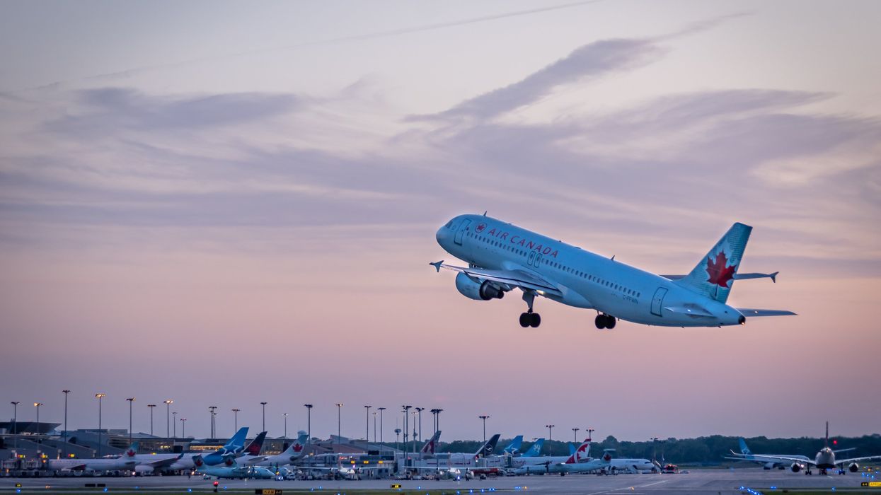 An Air Canada flight taking off from Montreal International Airport at dusk.
