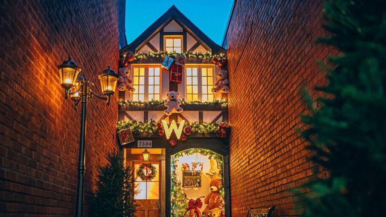 An alley decorated in Verdun to have an English home façade covered in lights, holiday decorations, stuffed bears and presents.