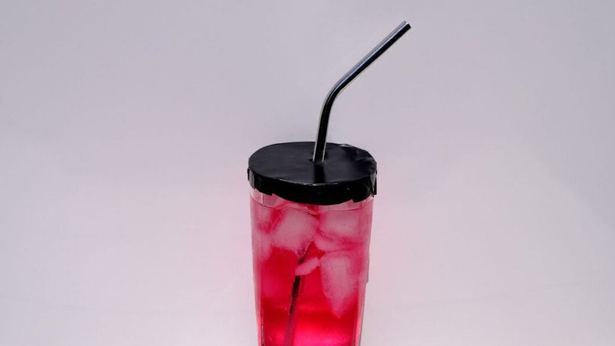 An aluminum guard covers a drinking glass.