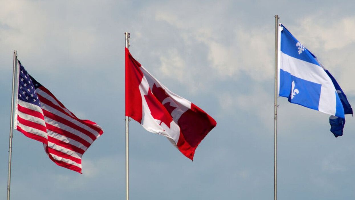 An American, Canadian, and Quebec flag wave.