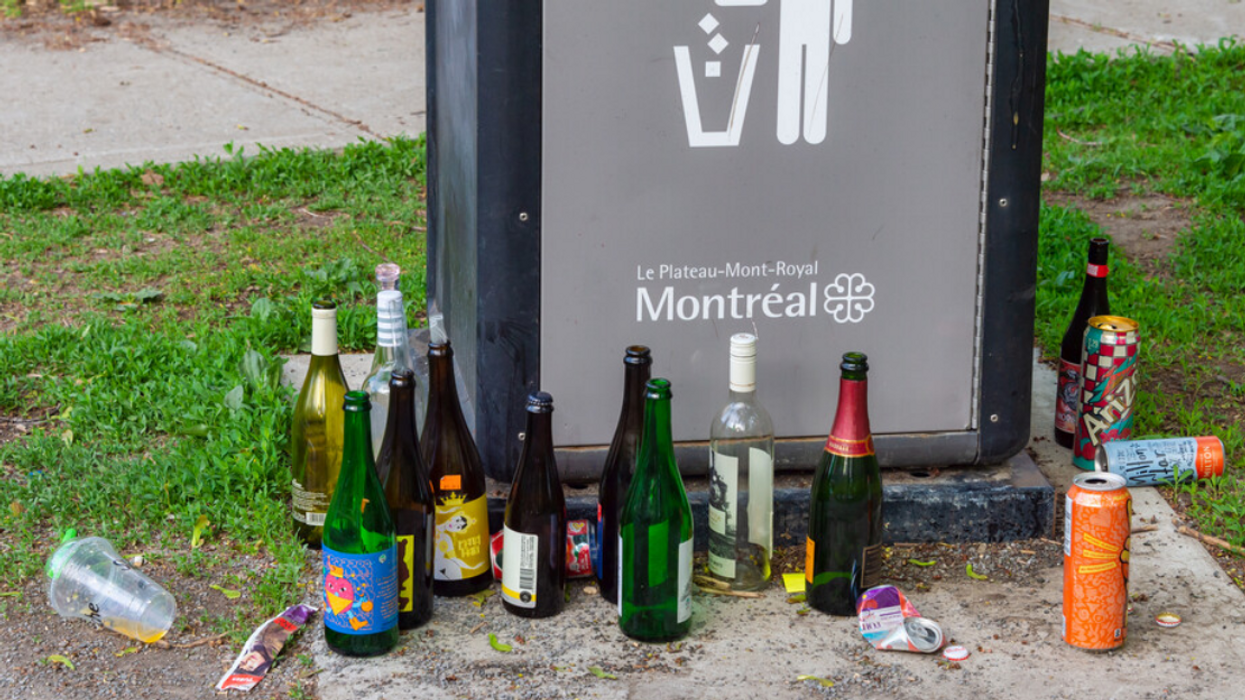 An array of empty alcohol bottles outside a municipal trash can in Montreal.