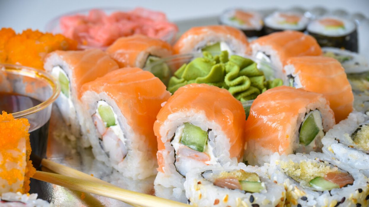 An assortment of sushi rolls (maki) with chopsticks, ginger and wasabi.