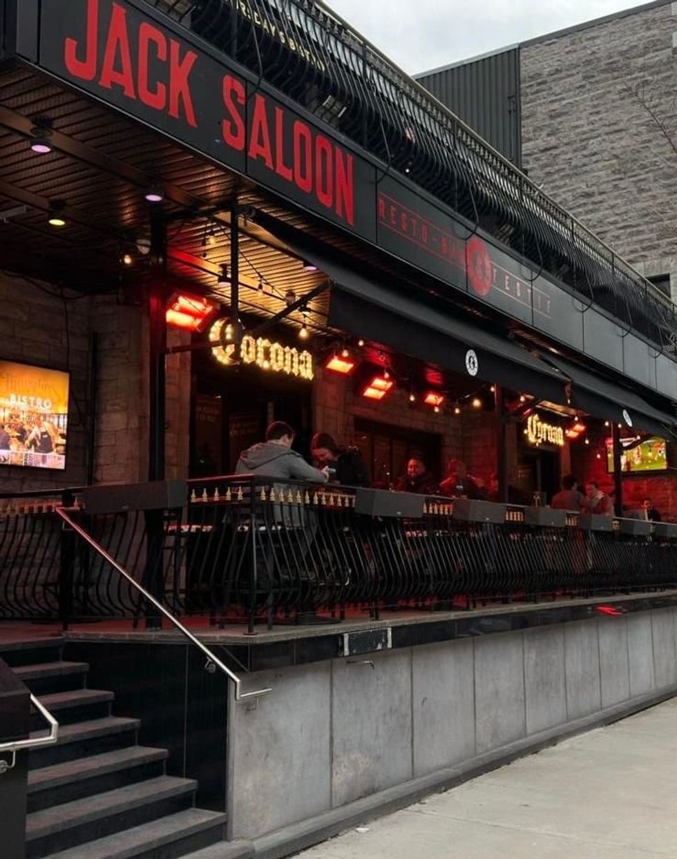 An exterior shot of Jack Saloon shows people sitting on the terrasse.