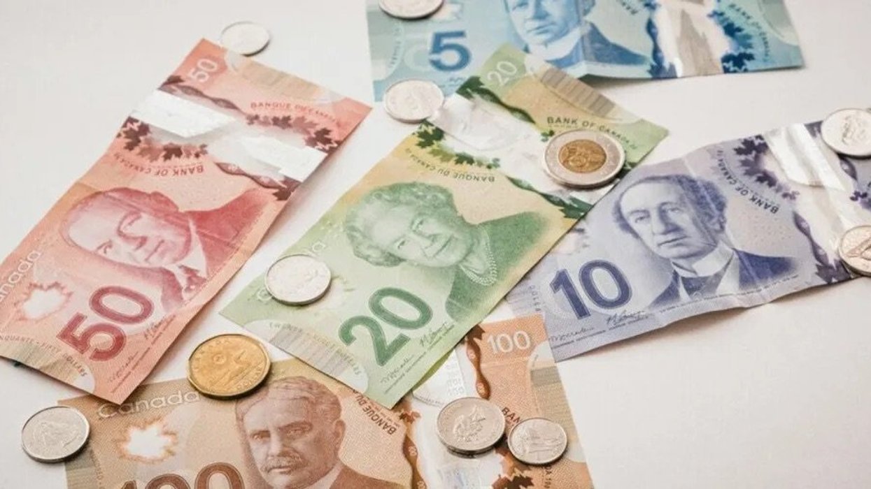 Assorted Canadian bills and coins on a white table.
