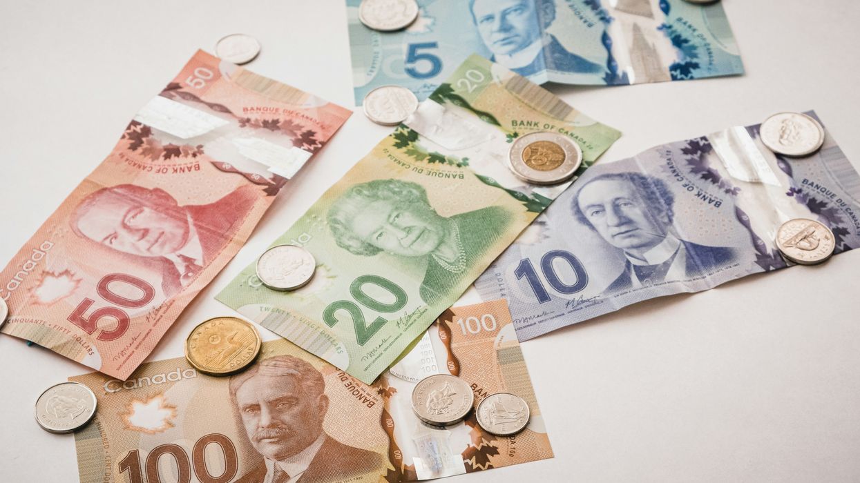 Assorted Canadian coins and bills on a white table.