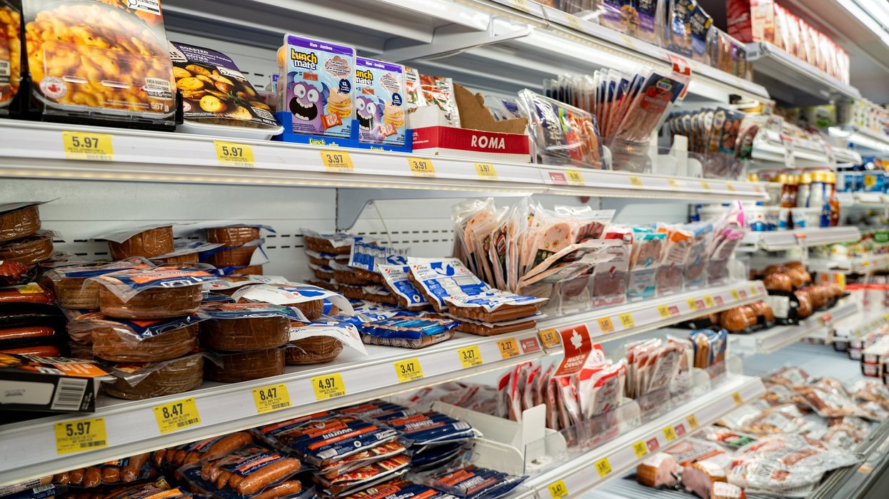 Assorted deli meats and packaged foods displayed in grocery cooler.