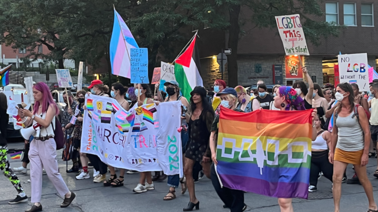 Attendees and organizers hold banners at the 2022 Montreal Trans March.