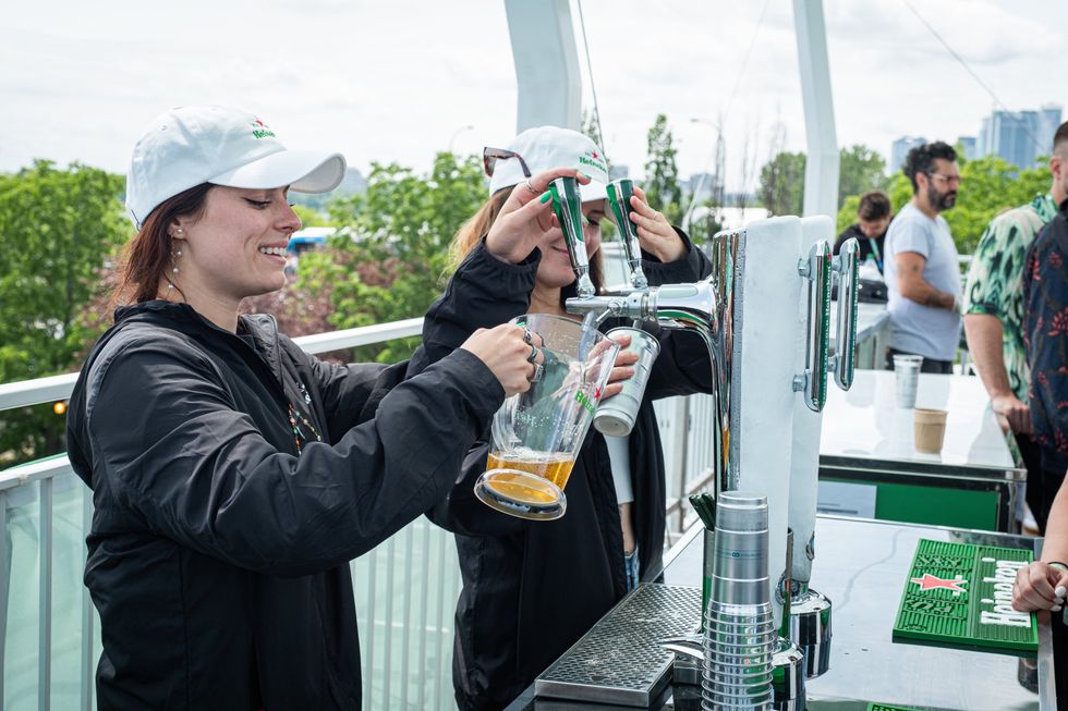 Bartenders pulling pitchers of Heineken.