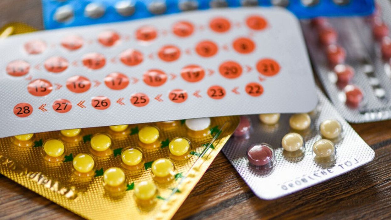 Birth control pills on wooden background.