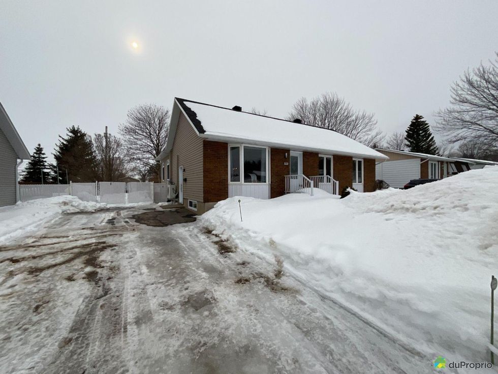 Bungalow with snow in the front yard in Trois-Rivi\u00e8res, Quebec.
