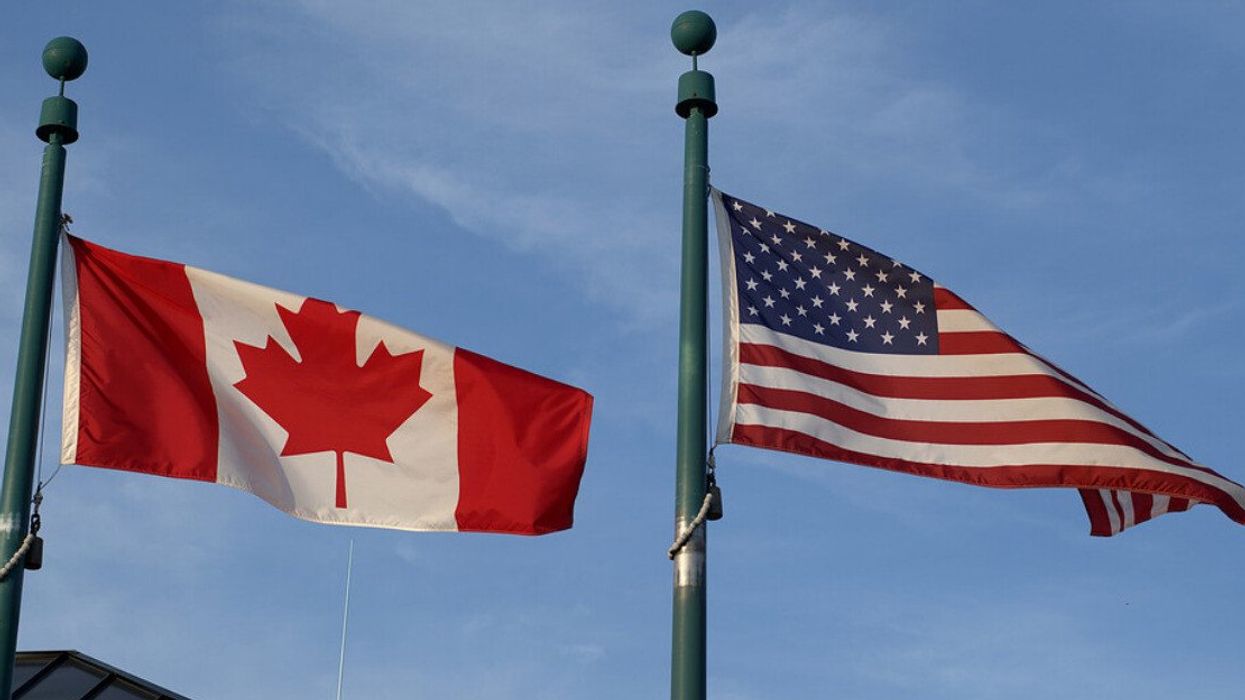 Canada and USA flags fly alongside each other.