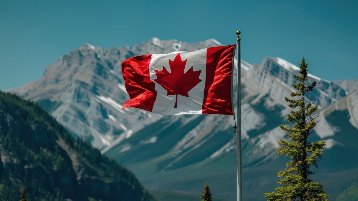 Canada flag waves in front of a Rocky Mountain backdrop (illustrative).