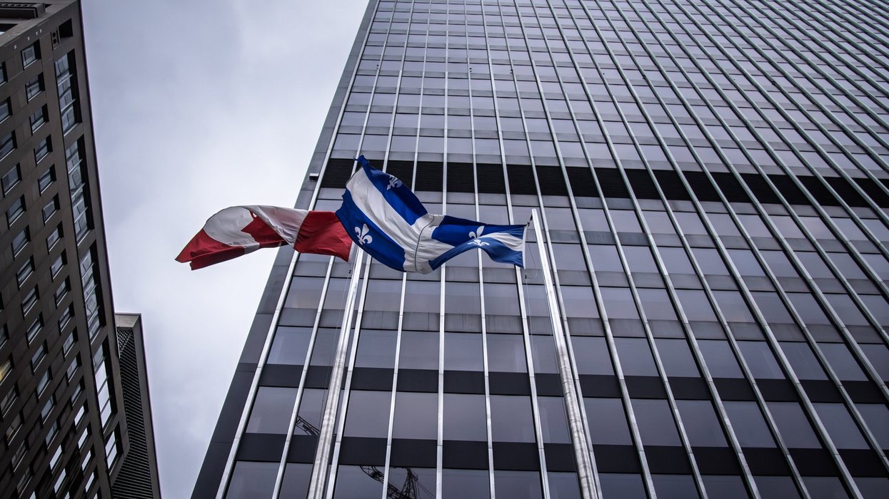 Canadian and Quebec flags wave in front of a tall Montreal skyscraper, representing business, government, investment and corporate.