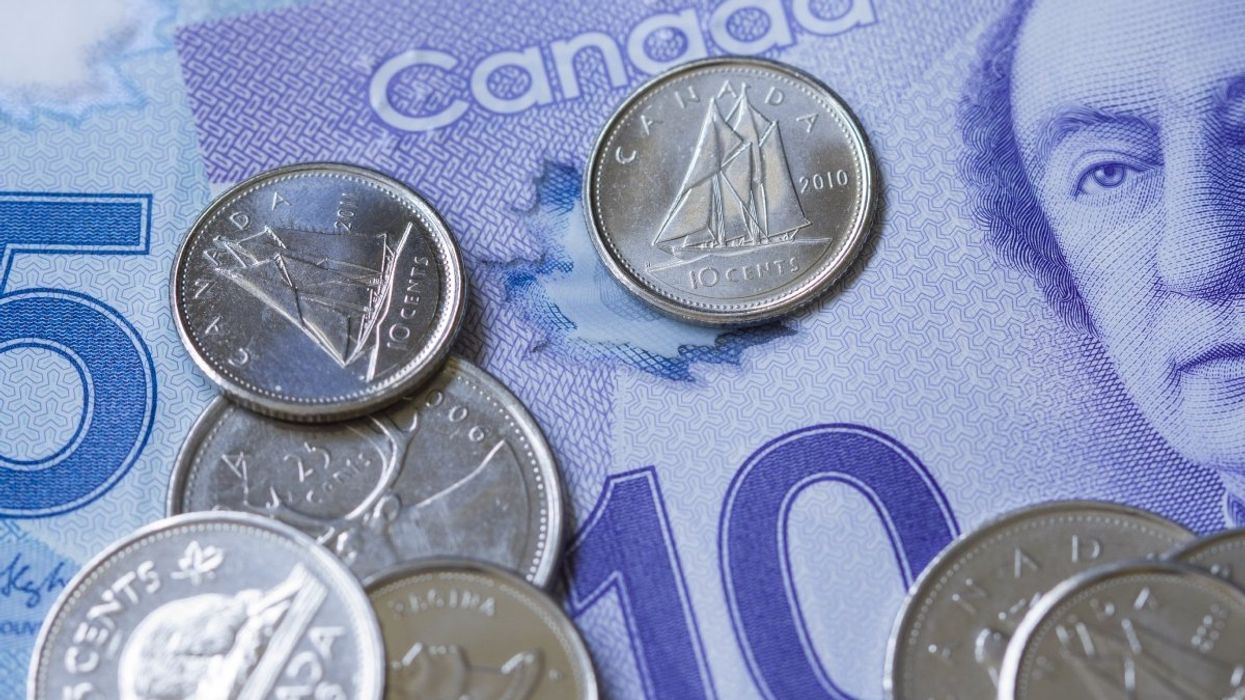 Canadian coins laying atop a Canadian $10 and $5 bank note.