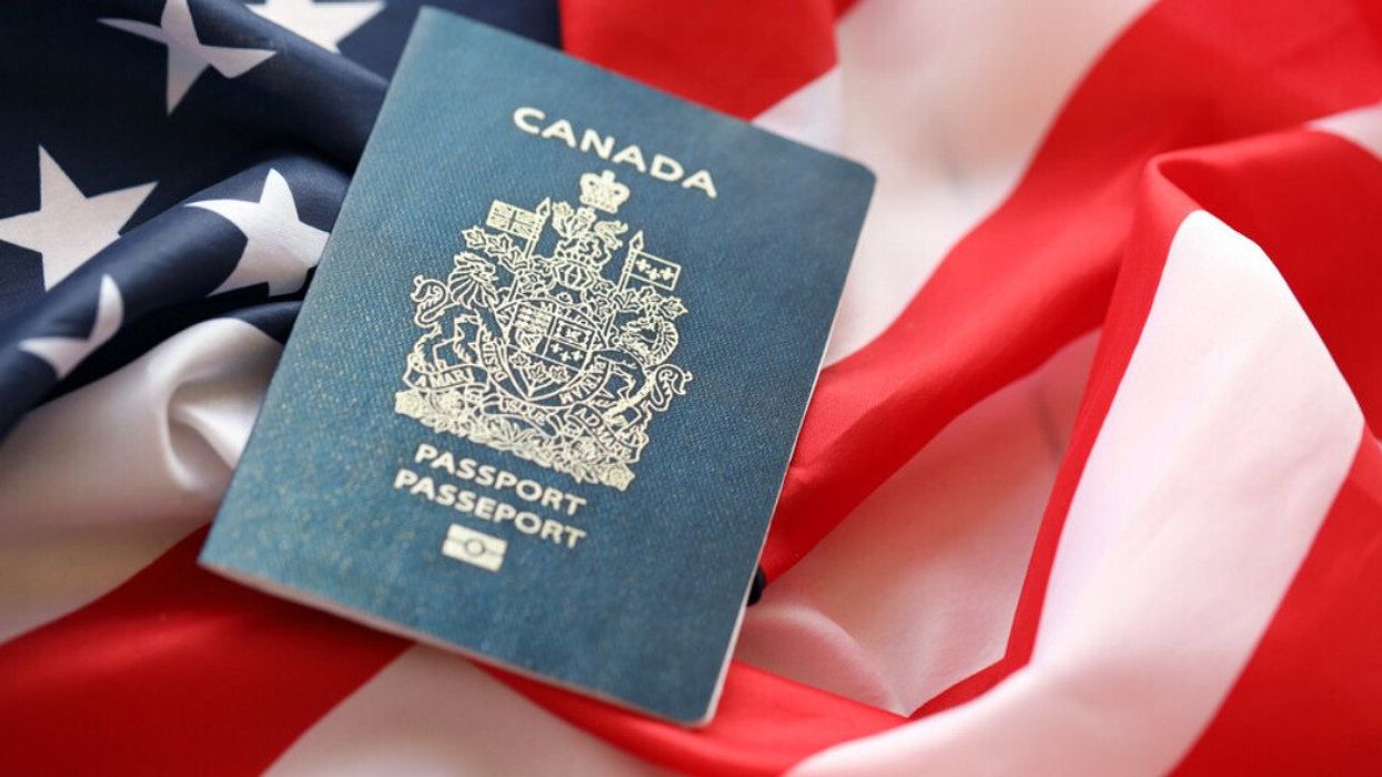 Canadian passport on United States national flag background close up.