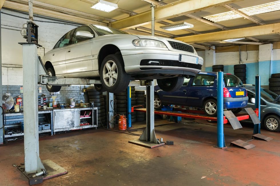 Cars on raised platforms in a garage.