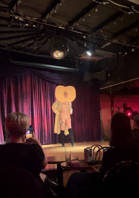 Classy Clare walking on stage in a butt costume.
