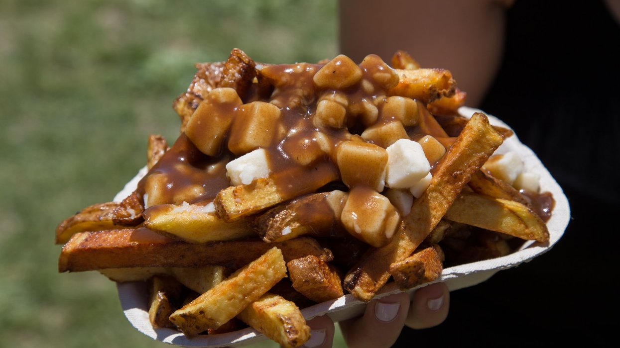 Closeup of poutine in a takeout container.