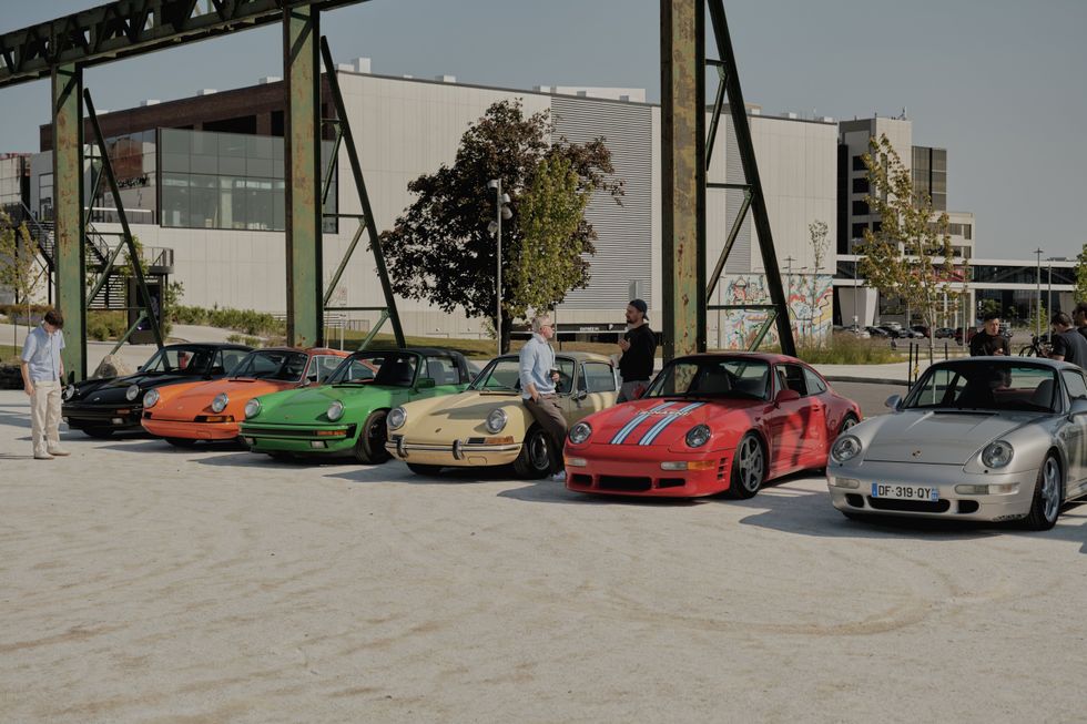 Colorful classic Porsche cars lined up at outdoor automotive event.