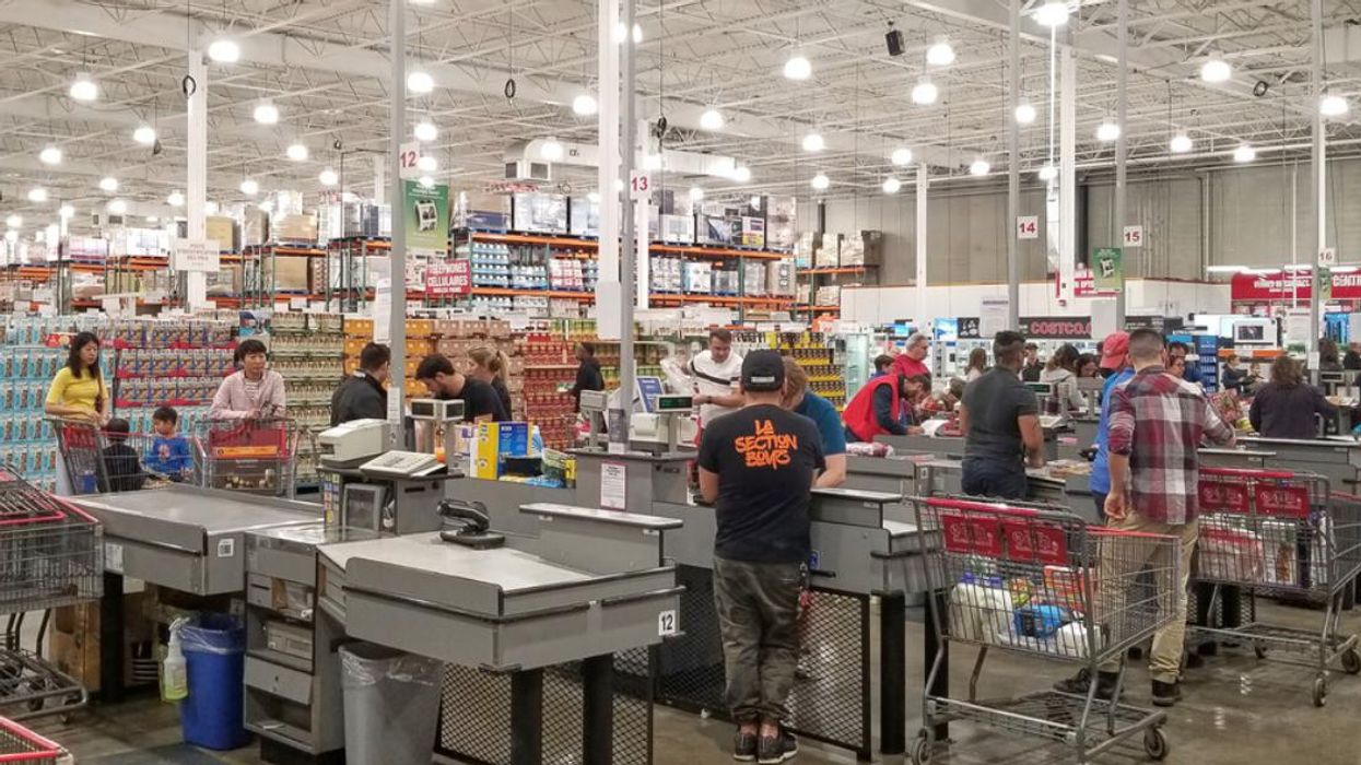 Costco members check out at a cashier.