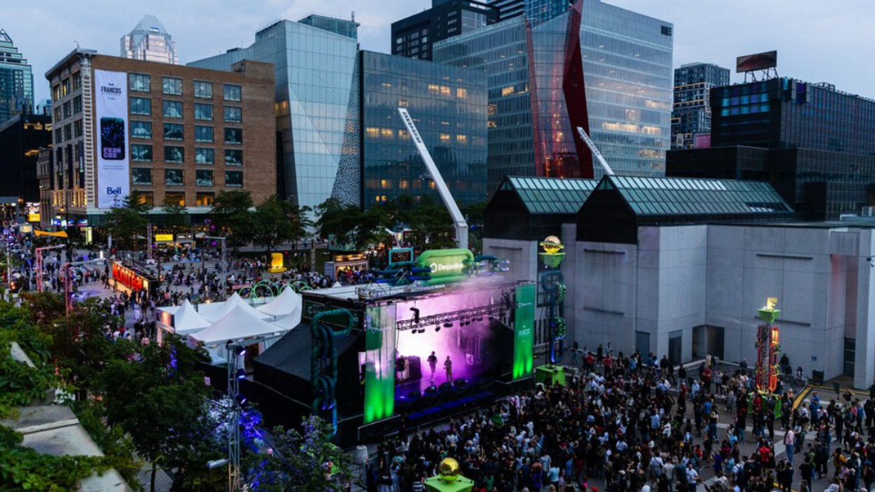 Crowds in front of a lit-up stage during a Francos de Montreal concert, with downtown buildings in the background.