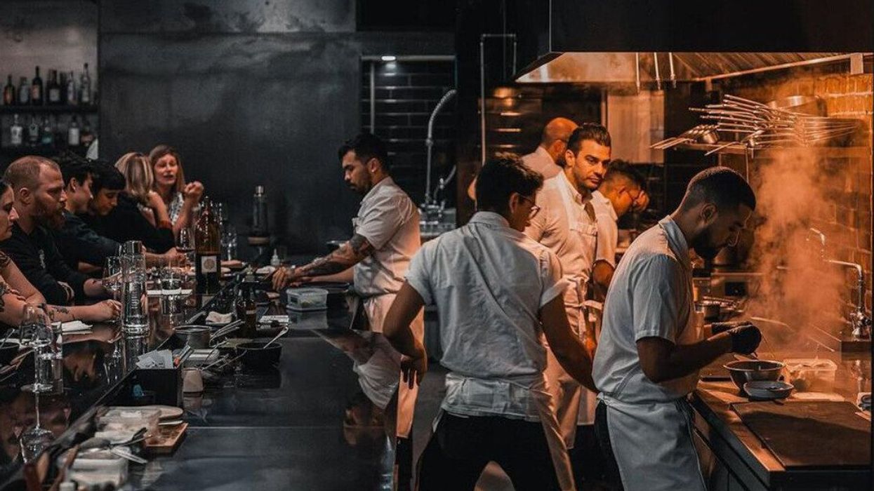 Diners at the bar of Cabaret L'Enfer in Montreal watch meal preparation.