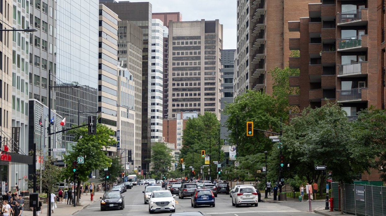 Downtown Montreal street with traffic and skyscrapers.
