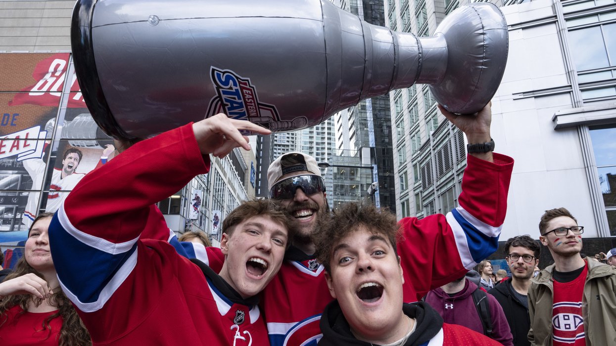 Fans in Montreal Canadiens jerseys hoist a fake inflatable Stanley Cup.