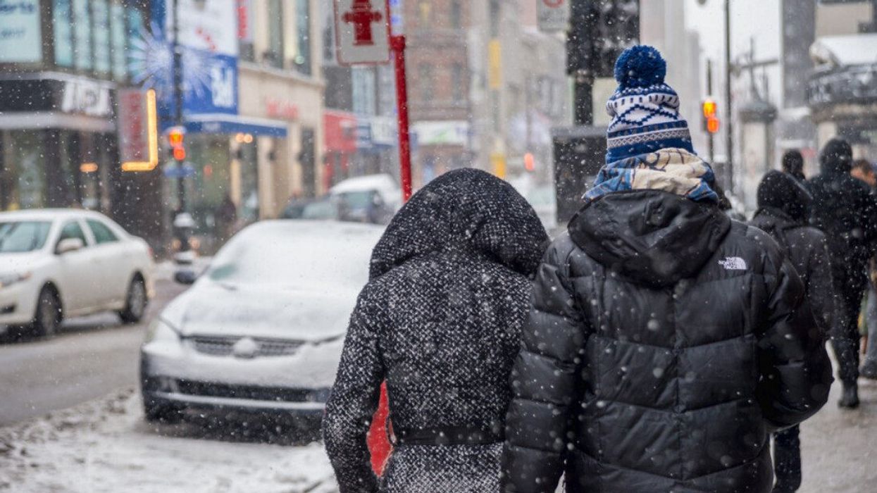 First snowfall of the season hits the city. Pedestrians on Sainte-Catherine Street in Downtown district.