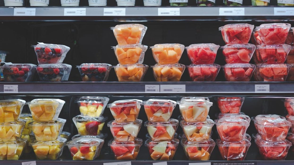 Fresh cut fruit containers stacked in the refrigerator section of a Canadian grocery store.