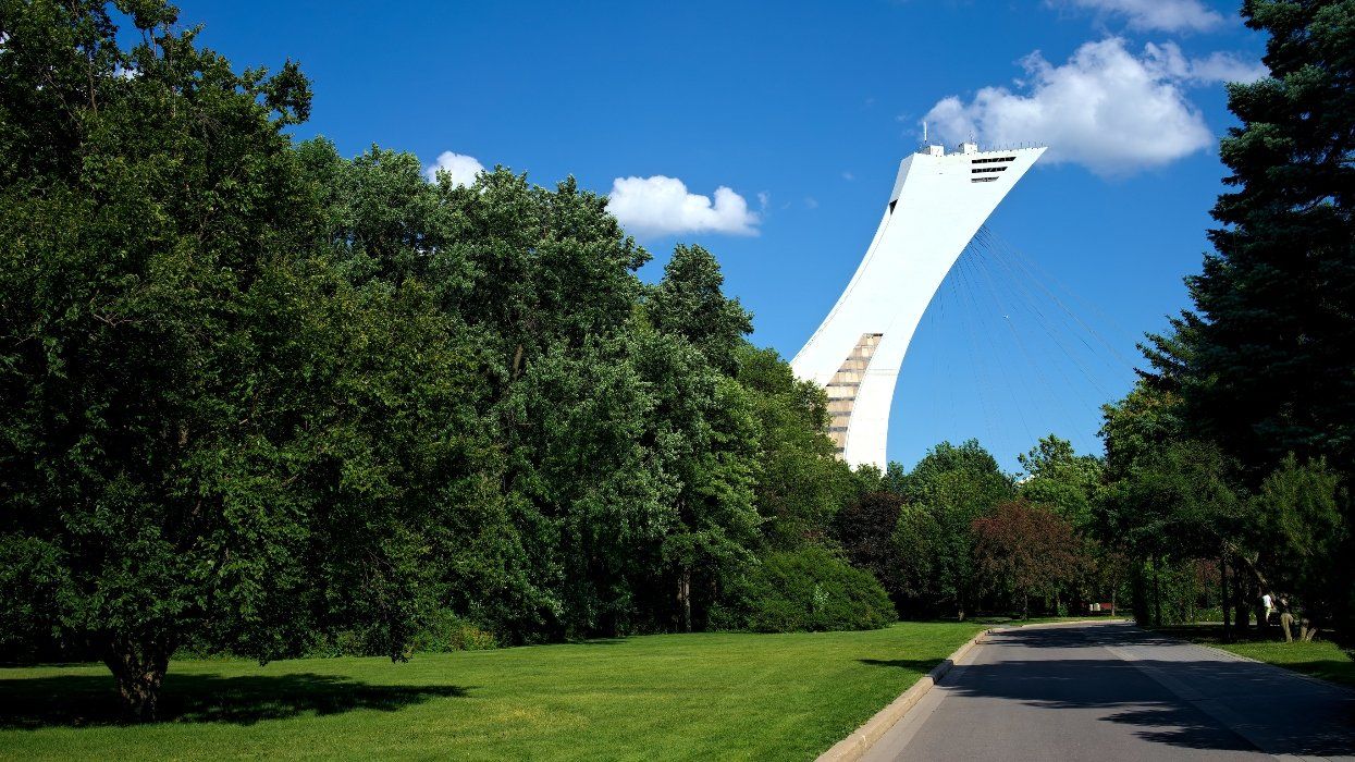 From the green paths at the Botanical Garden, one can see the high tower of the Olympic Stadium rising up into the blue sky of Montreal, Quebec, Canada