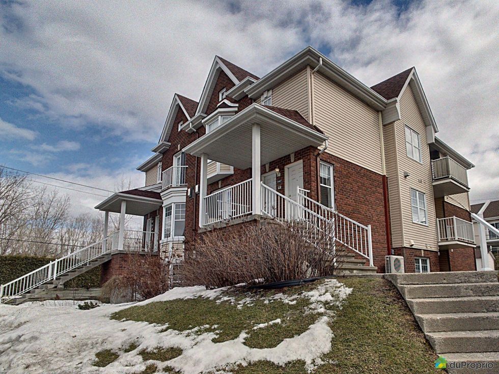 Front and side fa\u00e7ades of a condo complex in Laval, QC.