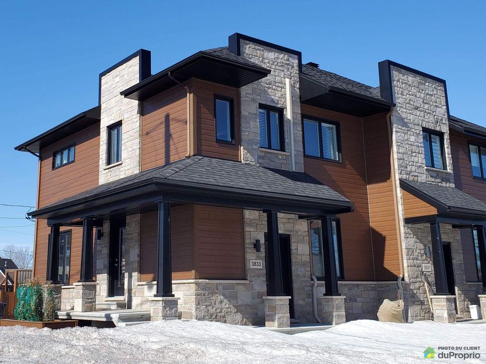 Front of a modern, two-storey, semi-detached home in L\u00e9vis, Quebec.