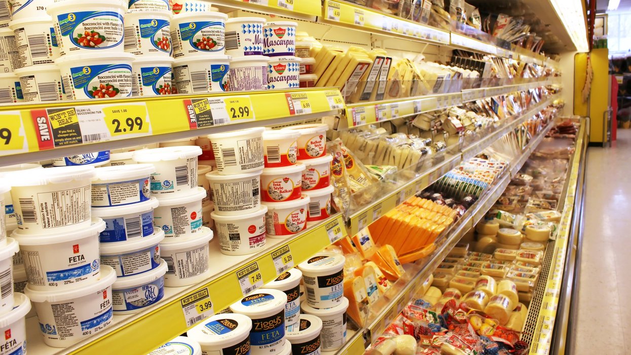 Grocery store cheese shelves. Different brands of cheese on shelves in a grocery store