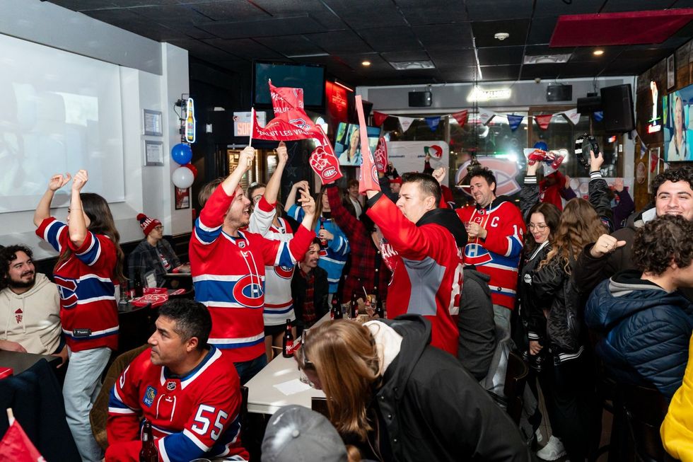 Habs fans cheering in jerseys at a hockey watch party.