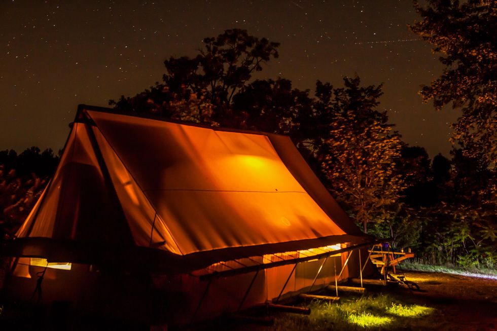 Illuminated tent under a starry sky in Quebec's Parc national de Plaisance.