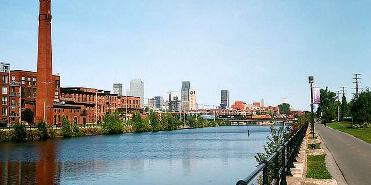 St-Henri uin montreal, buildings and a sidewalk next to a river. A good place to live if your looking for neighborhoods to live in Montreal