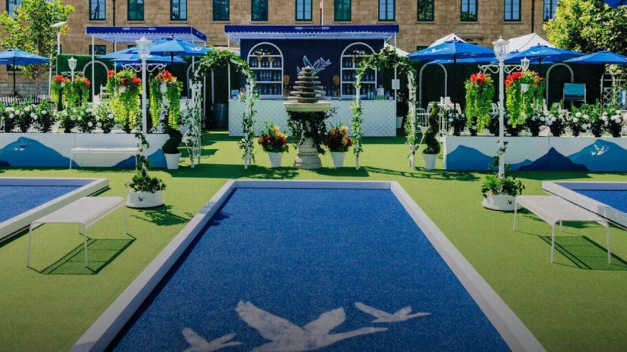 Jardin Pétanque with blue lanes for boules surrounded by greenery and a fountain.