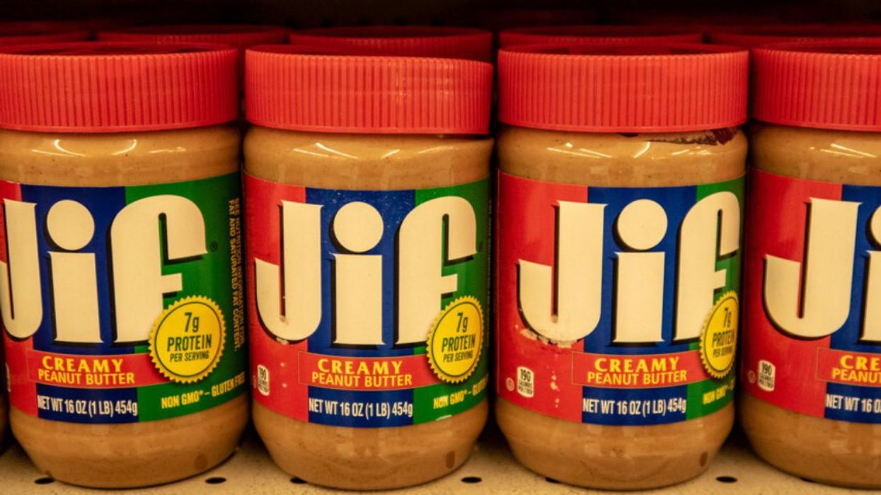 Jif brand creamy peanut butter lines a grocery store shelf.