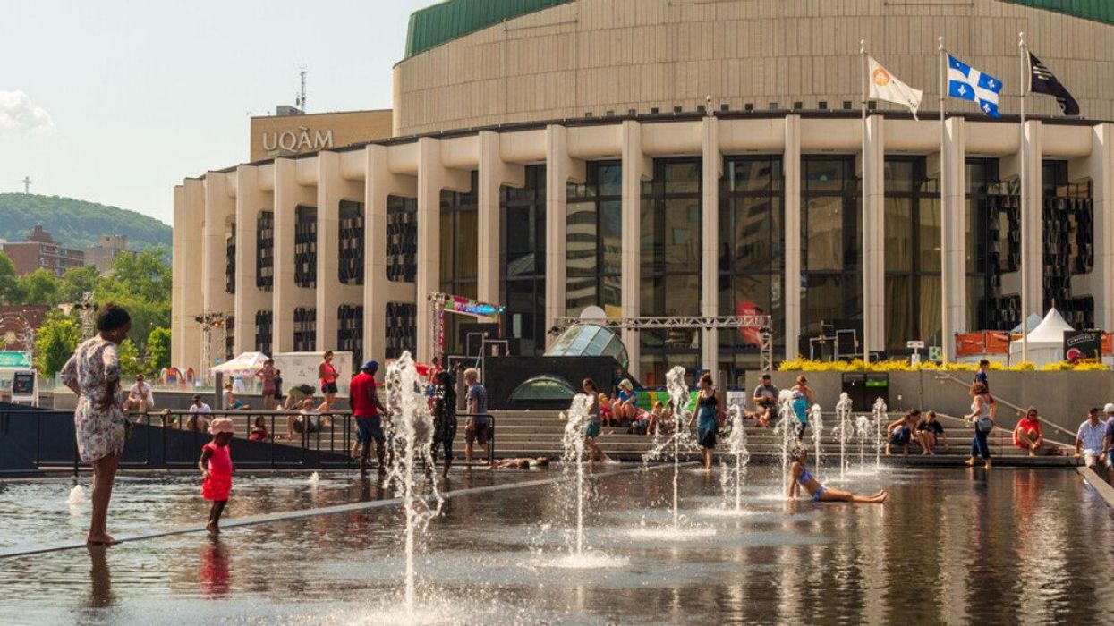 kids cooling off in the water basins of Esplanade of Place des Arts during a hot day.