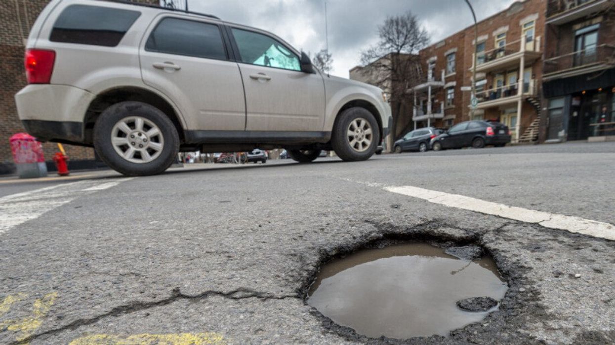 Large rounded pothole on Laurier street in Montreal, Canada.
