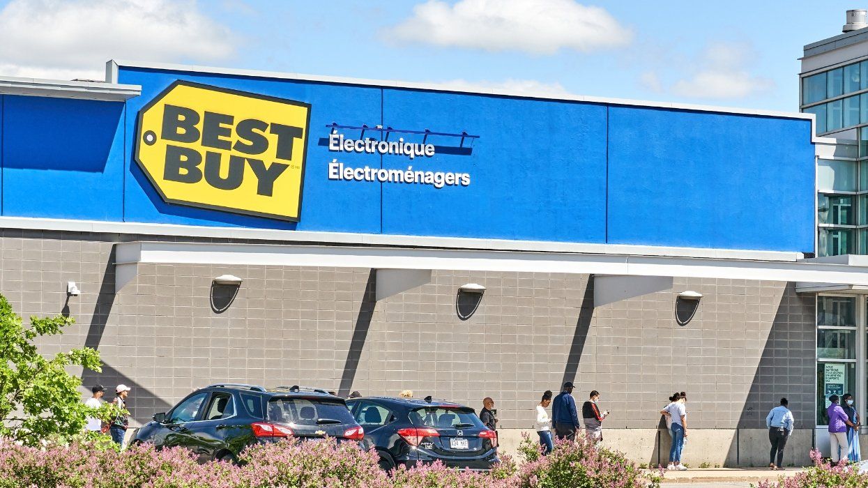 Line of people wearing masks and keeping social distancing waiting outside to enter Best Buy store. Montreal, Canada .