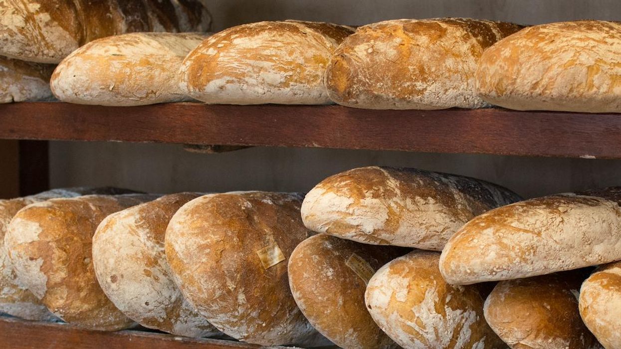 Loaves of bakery bread on shelves.