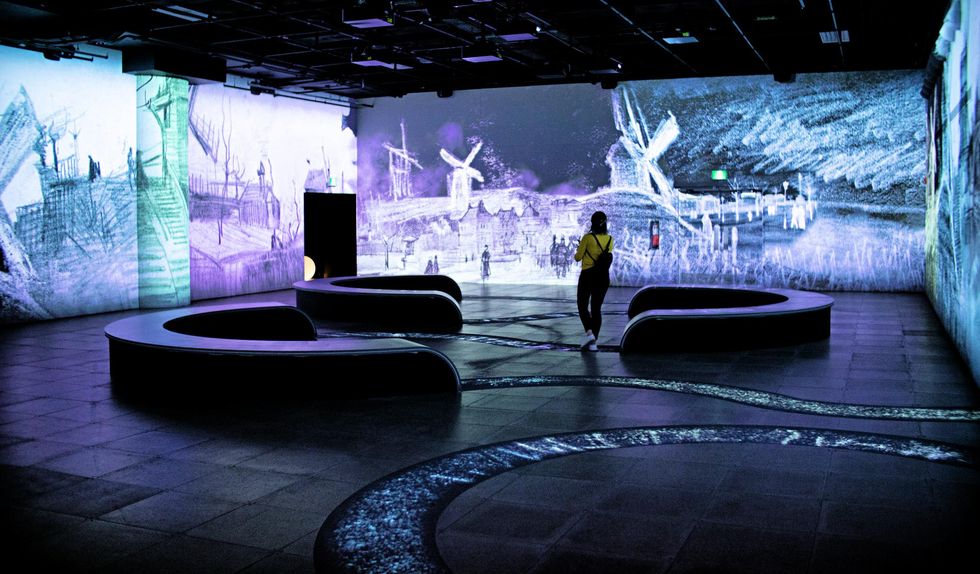 Looking at the exhibit in a projection room with dark benches.